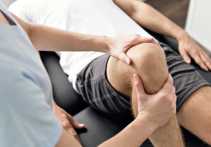 Physiotherapist assessing a knee joint